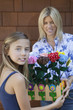 Photo: Portrait of a little girl handing over artificial flowers in crate to mother Portrait of a little girl handing over artificial flowers in crate to mother