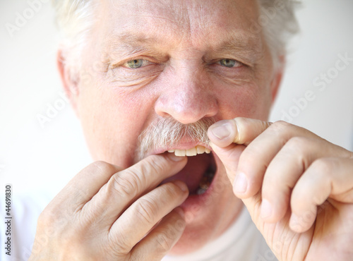 Photo: senior man flosses teeth senior man flosses teeth