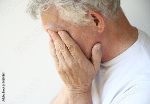 Photo: senior man covers his face with his hands senior man covers his face with his hands
