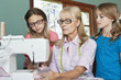 Granddaughters looking at grandmother sewing cloth
