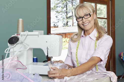 Photo: Portrait of a happy senior woman sewing Portrait of a happy senior woman sewing
