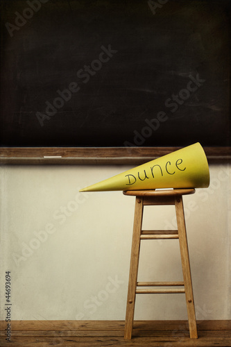 Photo: Yellow dunce hat on stool with chalkboard Yellow dunce hat on stool with chalkboard