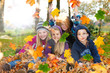 children playing with autumn leaves