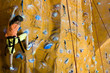 Climbing teenager girl to the top of wall