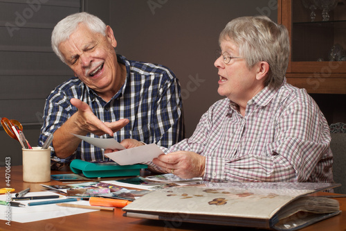 Photo: Senior couple choosing photos for album Senior couple choosing photos for album