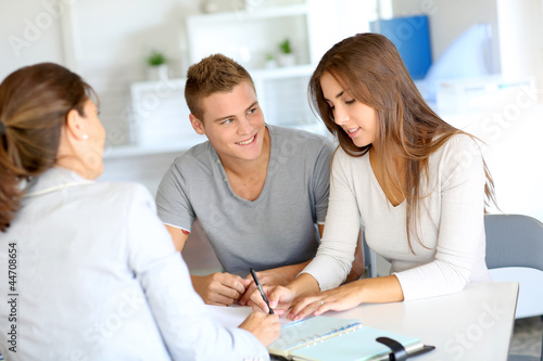 Photo: Young couple meeting financial consultant for credit loan Young couple meeting financial consultant for credit loan