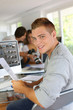 Young man sitting in office in front of desktop computer