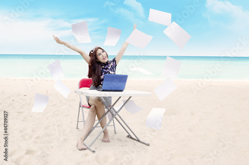 Photo: Young asian businesswoman expressing her success at beach Young asian businesswoman expressing her success at beach