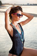 Beautiful brunette posing  on river bank..