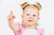 Foto: The girl shows a finger, on a gray background The girl shows a finger, on a gray background