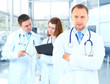 Portrait doctor smiling with colleagues in background