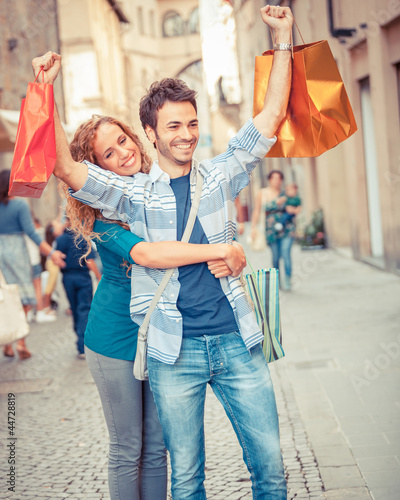 Photo: Happy Young Couple with Shopping Bags Happy Young Couple with Shopping Bags