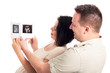 Photo: Happy pregnant couple with ultrasound pictures Happy pregnant couple with ultrasound pictures