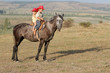 two young happy children riding horse on natural background