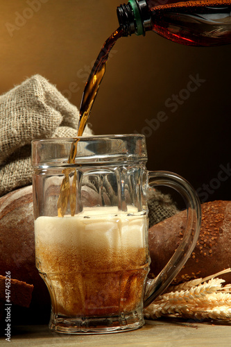 Photo: kvass poured into a mug and rye breads with ears, kvass poured into a mug and rye breads with ears,