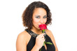 junge frau riecht an einer roten rose