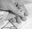 newborn baby hand on a male hand
