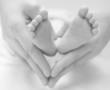 newborn baby feet on female hands