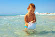 curious baby boy catches jellyfish in the sea, bad experience