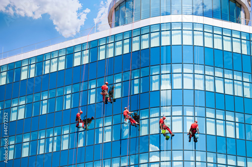 Photo: Workers washing windows in the office building Workers washing windows in the office building