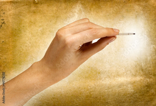 Photo: mano con pennino su sfondo anticato mano con pennino su sfondo anticato