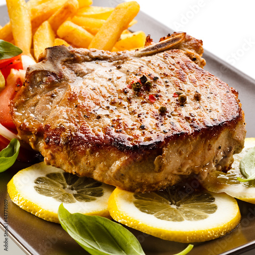 Photo: Grilled steaks, French fries and vegetables Grilled steaks, French fries and vegetables