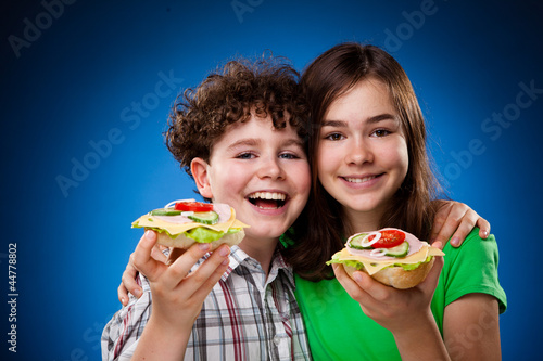Photo: Kids eating big sandwiches Kids eating big sandwiches