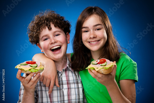 Photo: Kids eating big sandwiches Kids eating big sandwiches