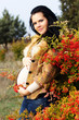 Portrait of beautiful pregnant woman walking in autumn park