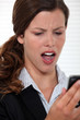 Woman staring in disbelief at her mobile phone
