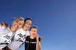 Three women stood outdoors with headphones