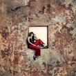 girl sitting on window of an abandoned building