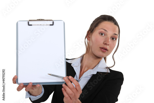 Photo: Business professional pointing to a clipboard Business professional pointing to a clipboard