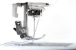 Sewing machine part with needle closeup on white background