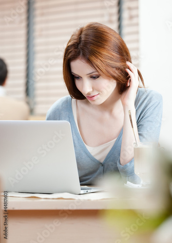 Foto: Woman is surfing on the internet on the personal computer Woman is surfing on the internet on the personal computer
