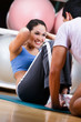 Photo: Woman does situps with coach in training gym Woman does situps with coach in training gym