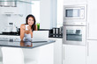 Photo: Happy woman in her kitchen Happy woman in her kitchen