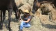 Young Beautiful Girl and her horses resting near a haystack