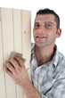 Carpenter sanding plank of wood
