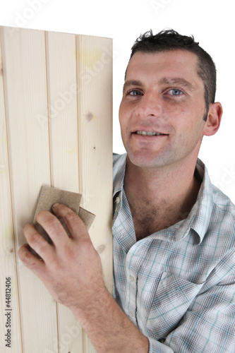 Photo: Carpenter sanding plank of wood Carpenter sanding plank of wood