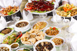 mixed Chinese food with chef holding some dishes