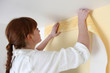 Woman putting up a wallpaper border