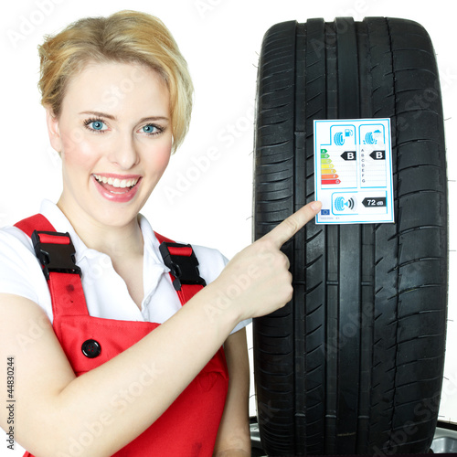 Photo: Female car mechanic showcases tire label Female car mechanic showcases tire label