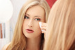 Photo: Woman cleaning her face with cotton pad Woman cleaning her face with cotton pad
