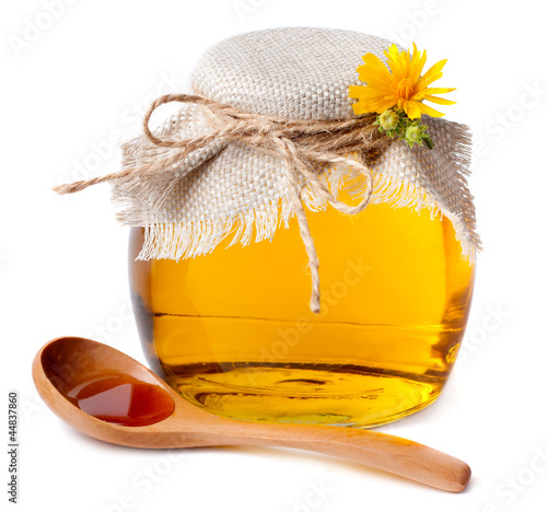 Photo: Honey in the pot and a wooden spoon Honey in the pot and a wooden spoon