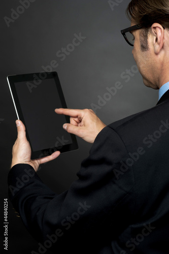 Photo: Rear view of boss browsing on new tablet pc Rear view of boss browsing on new tablet pc