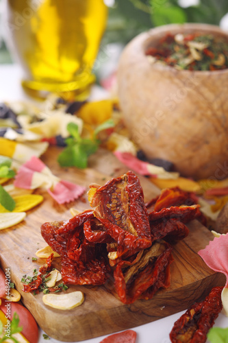 Photo: Dried tomatoes, garlic, basil, ingredients of Italian cuisine. Dried tomatoes, garlic, basil, ingredients of Italian cuisine.