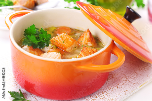 Photo: Soup with vegetables and salmon in ceramic pot. Soup with vegetables and salmon in ceramic pot.