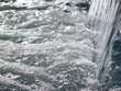 Close up of water splashing into swimming pool