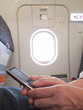 Close up of woman text messaging on cell phone in airplane